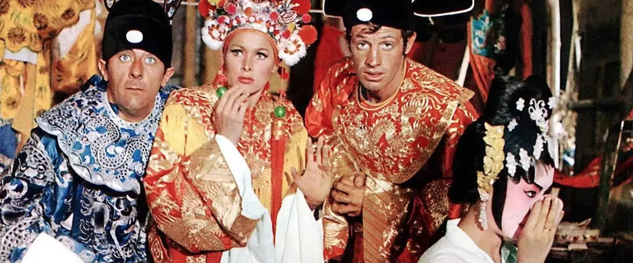 Les Tribulations d'un Chinois en Chine - Cet homme de Rio est en HAUT au-dessus de l'Himalaya... en HAUT au-dessus du Yang-tsé... en HAUT dans un ballon... en HAUT sur scène avec une strip-teaseuse... en HAUT dans la ville de Hong Kong... Vous ne pouvez pas garder un grand aventurier en BAS – image d’arrière-plan